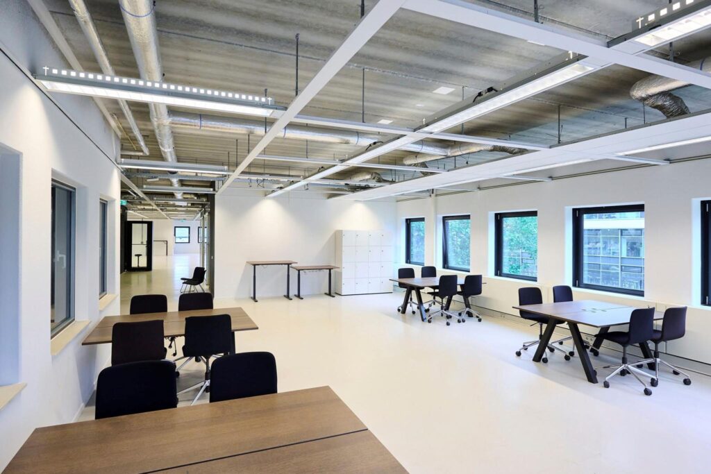 Moderne, lichte kantoorruimte aan het John M. Keynesplein met flexwerkplekken, bureaus en lockers.